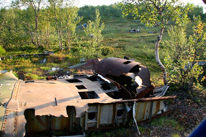 Et av de mange flyvrakene ved veien. Dette er russisk.