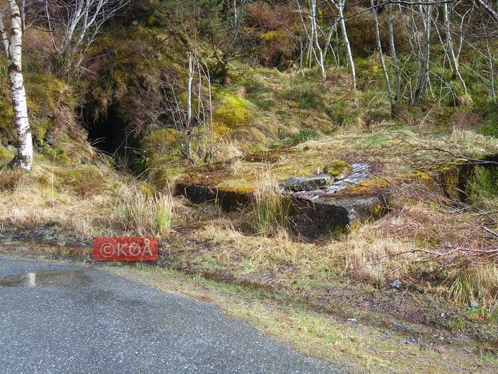 Liten bunker og brønn(?) ved parkeringsplass.