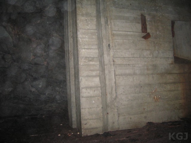 På nivå 3 en betongvegg med skyteskår som skråer oppover inngangstunnelen