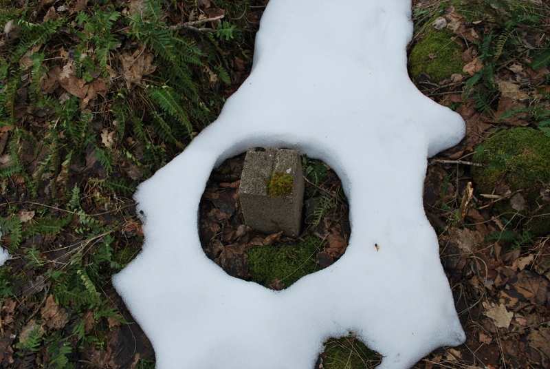 En kabelmerkestein som stikker frem av snøen, nå er det vår