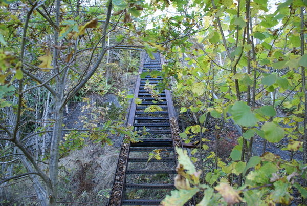 Trapp med trallespor opp fjellveggen til åpning i fjellet