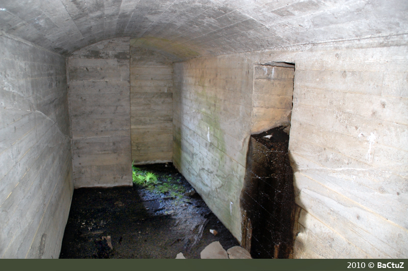 Dekningsbunker (11) med nødutgang på høyre vegg, sett innenfra mot utgang.