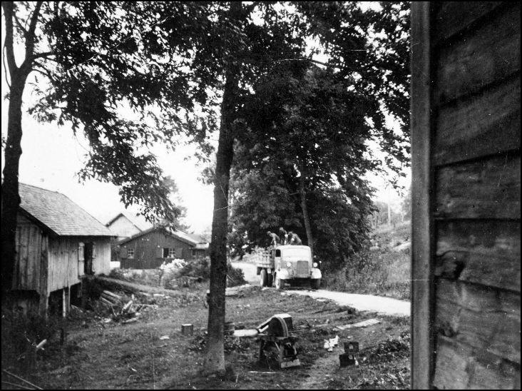Bilde tatt i Maidagene 1945. Tyske soldater m. hvite armbånd tømmer noen av låvene som var ibruk som lager, for utstyr.