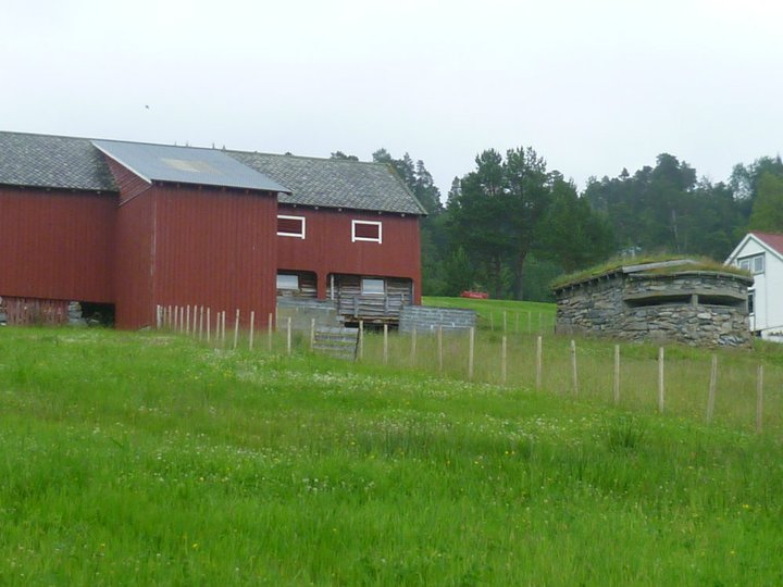 En av låvene som ble rekvirert, samt kommandobunkeren v. batteriet, sett forfra. Det hvite huset som vi skimter helt til høyre, var et av gårdshusene som ble rekvirert.