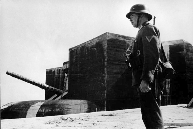En tysk vakt ved en av kanonene/casemate'ene på Batterie Lindemann.