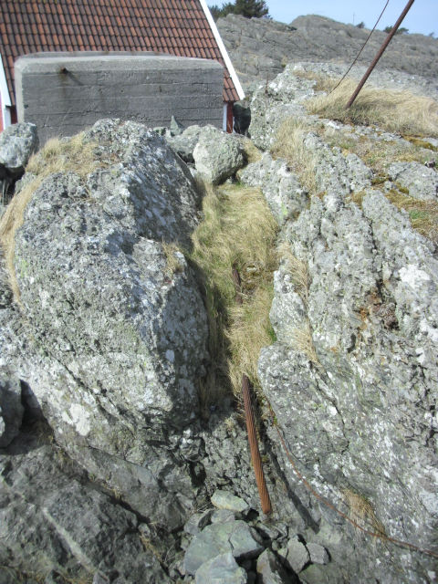 Kabelgate forran bunkeren sett fra sjøsiden. En 4-5cm tykk kabel ligger i kabelgaten. Dere får vurdere om den er fra krigen da eg ikke har peiling på slikt.