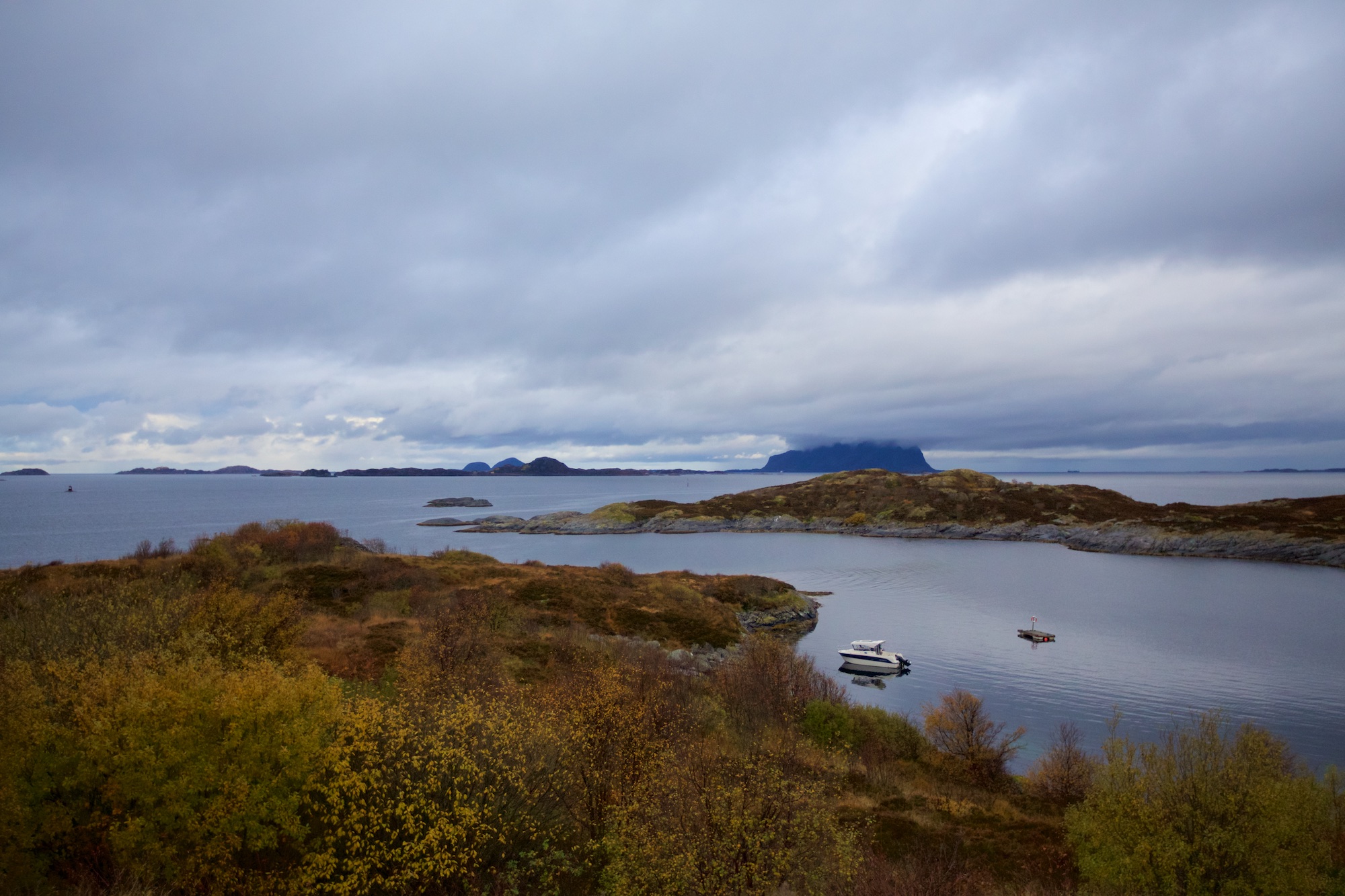 Utsikt vestover fra fortet. På land, like innenfor der båten ligger fortøyd, var det minefelt da fortet var operativt.