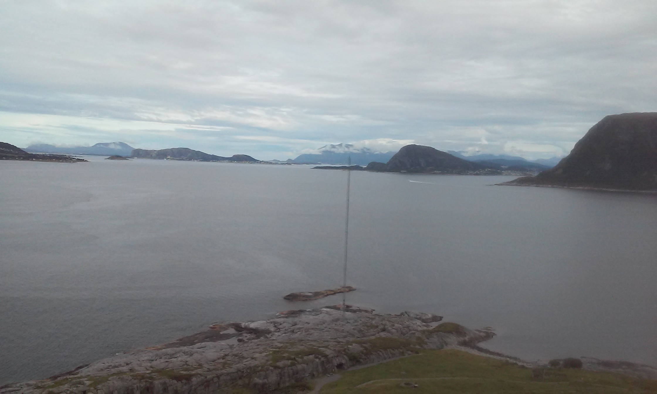 Utsikt nordover leia. Stavneset på Hessa rett til høyre for masta, Tueneset rett på masta, Bjørnøya ett stykke til høyre for Valderøya, Vigra uti venstre bildekant, kystfort på rad og rekke...