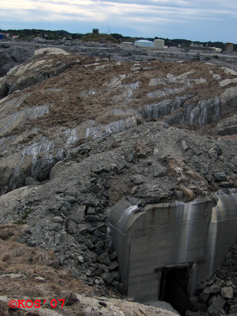 Sett fra toppen av Kanon 1.<br />I horisonten sees det karakteristiske byggtårnet, og skrått nedenfor til høyre på bildet er Leitstand.<br />I forgrunnen dekningsbunkers.