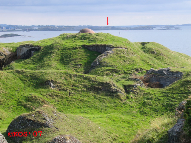 Sørste kanon (32 V 286839 6594667) sett fra &amp;quot;Leitstand&amp;quot;.<br />I bakgrunnen HKB 68/977 &amp;quot;Storøy&amp;quot;, der nordre kanon befinner seg som vist med pilen.